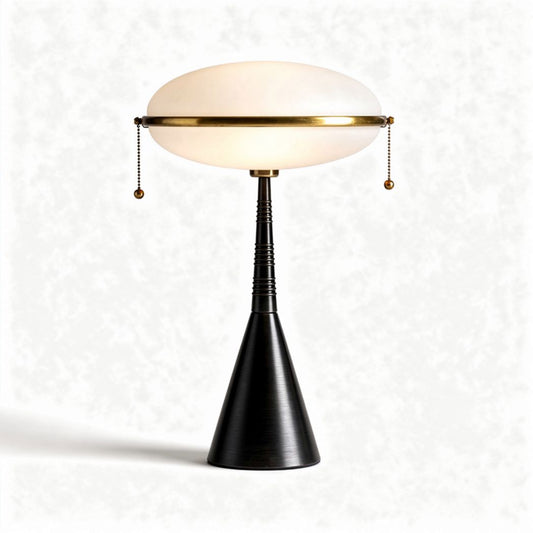 Tafellamp met glazen kap en metalen voet in zwart en goudkleurig design